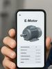 Elektromotor App am Handy – Das komplette Diagnosetool direkt an der Maschine, im Bild eine KI Version zu dm Text, ein Monteur (ohne Identität) mit einem offenen E Motor vor sich und einem Handy.
