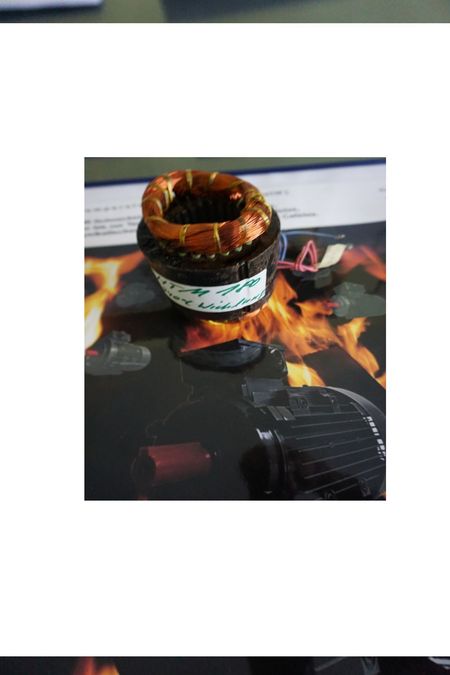 Elektromotor HTM Kosten – was kostet ein Hochtemperaturmotor wirklich? im Bild ein kleiner HTM Stator (Blechpaket bewickelt), Synonym dazu, er steht im Feuer (Feuerplakat drunter)