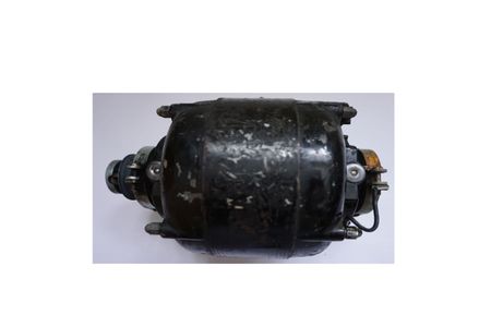 Elektromotor neu wickeln – warum Reparieren oft die bessere Wahl ist, im Bild ein sehr sehr alter kompakter E Motor (schwarz), rechts hinten ist die Welle mit Ankerwicklung noch zu sehen, vorn links die Welle etwas zu sehen, noch mit 4 Zugstangen gehalten. 